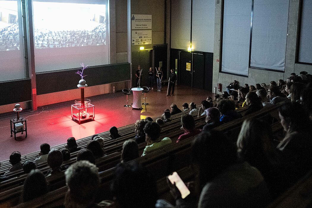 Studierende sitzen im Hörsaal und sehen sich die Show der Event-Physik an.